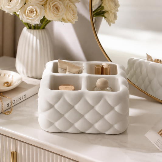 White ceramic organizer with decorative items on a vanity table.